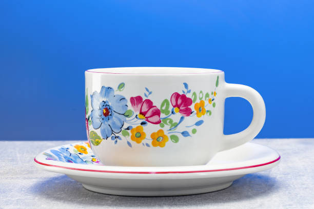 Handmade mug with flower ornament on a plate