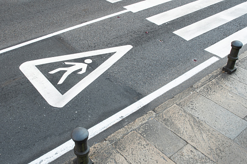 Pedestrian sign painted on the asphalt of a city road. Zebra crossing concept