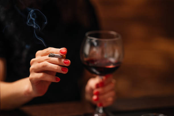 Lonely beautiful woman sitting on the bar, smooking cigarette and drink wine. stock photo
