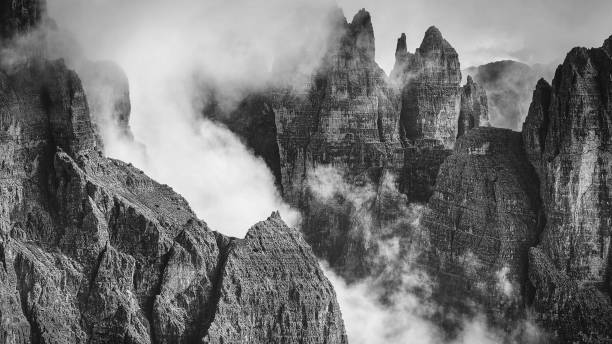 istock Black and white rocky mountains view covered with clouds, Dolomites 1203941718