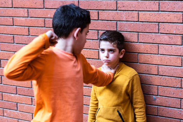 Little kid hitting another on the school. Bullying concept