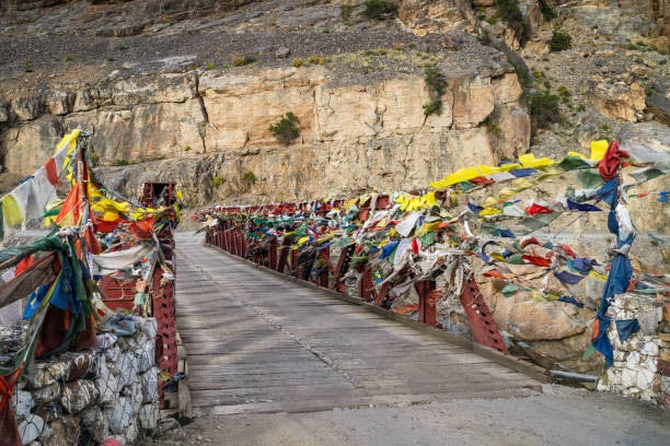 ヒマラヤの仏教の祈りの旗を持つ川に架かる鋼鉄橋。カザ、インド。 - kaza ストックフォトと画像