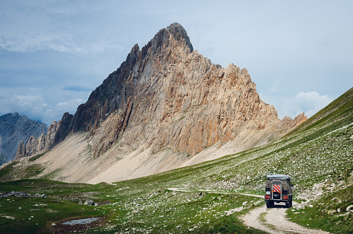 Off road caravain driving on a narrow path near the Rocca La Meja, famous mountain peak in che Alps of Piedmont, italy