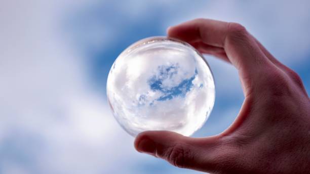 istock Male Hand is Framing Cloudscape by a Glass Ball 1203944080