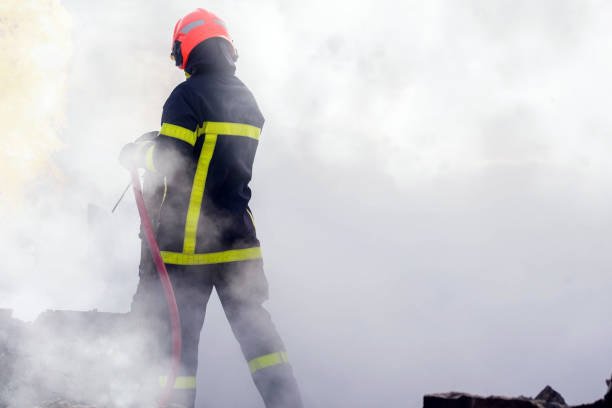 firefighter in thick smoke during a fire firefighter in action close up fire hose photos stock pictures, royalty-free photos & images