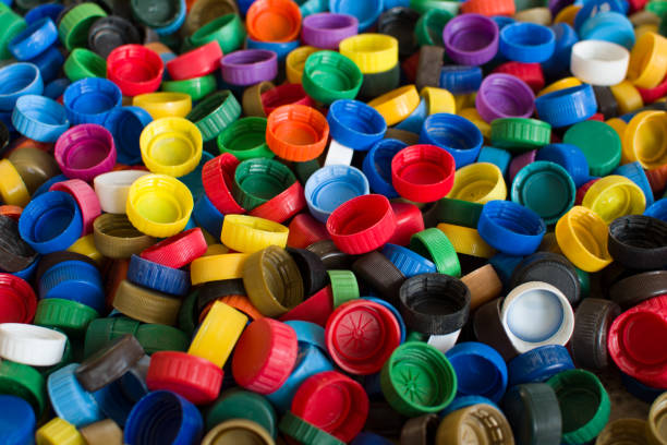 istock Plastic bottle caps background. Cap material is recyclable.Remove lids from plastic bottles before recycling them 1203947380