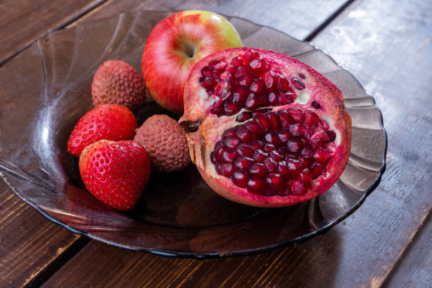 Fruits on plate: pomegranate , apple strawberry  and lychee