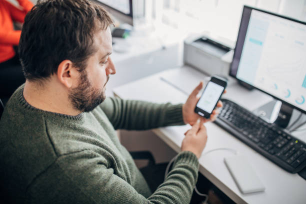 istock Young man working in the office and using power bank 1203952619