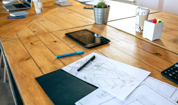 istock Workplace of an architect with blueprints and sketches 1203959349