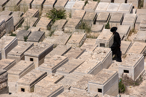 JERUSALEM, ISRAEL - MAY 16, 2018: Orthodox Jew  visiting the graveyards in the Jewish Cemetery on the Mount of Olives where according to midrash the Resurrection of the Dead would begin