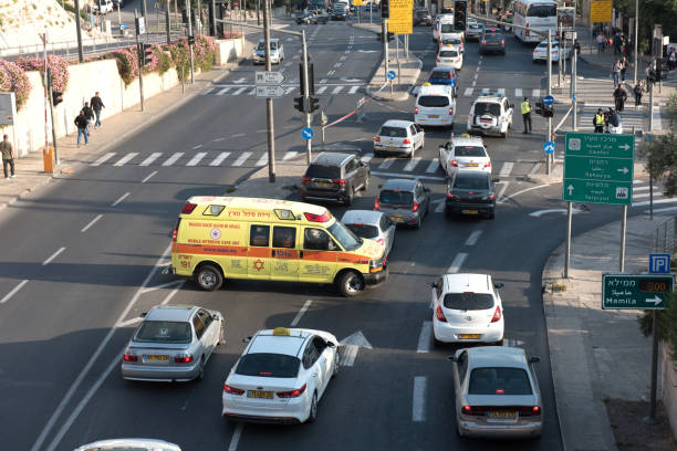 Ambulance car transporting injured person to hospital in Jerusalem, Israel JERUSALEM, ISRAEL - MAY 15, 2018:  Magen David Adom ambulance car transporting injured person to hospital in traffic jam ambulance in israel stock pictures, royalty-free photos & images