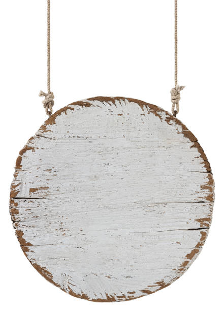 istock Old weathered worn white circular wooden board sign panel, hanging by old rope, isolated on white, clipping path included. 1203964144