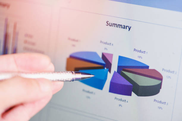 istock Business man holding a pen on diagram graphs business chart summary on screen working in the office - business report plan concept 1203965584