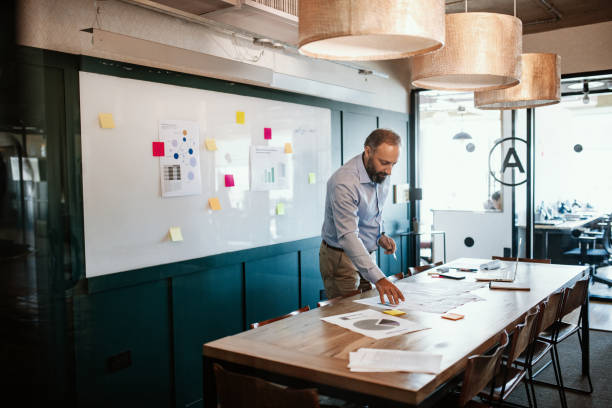 istock Mature businessman in office analyzing research reports 1203967816