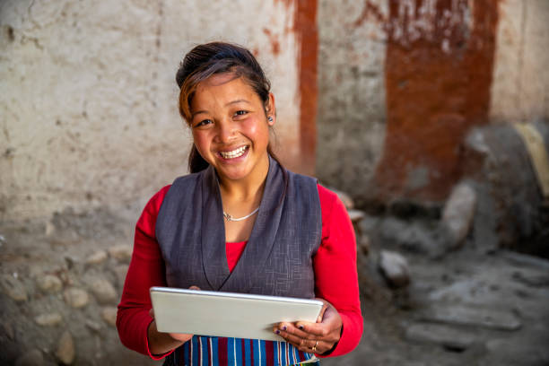 Tibetan young woman using digital tablet, Upper Mustang, Nepal