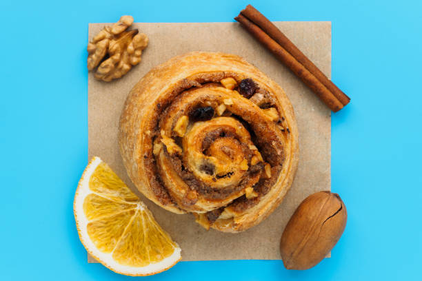 istock Cinnamon bun with nuts and lemons on a blue background 1203969279