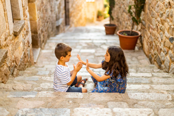 Two little kids playing on a stairs in a summer day