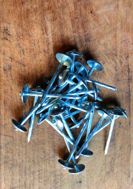 istock Steel nails on wooden board. construction concept 1203971559