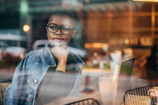 istock Black woman sitting alone in cafe and using laptop 1203971729