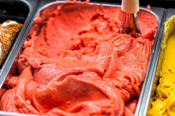 macro primo piano di gelato al sorbetto rosa rosso al sapore di fragola con scoop vorticoso in mostra nel negozio di caffetterie nella famosa firenze italia firenze centrale mercato - ice cream parlor ice cream dessert italian culture foto e immagini stock