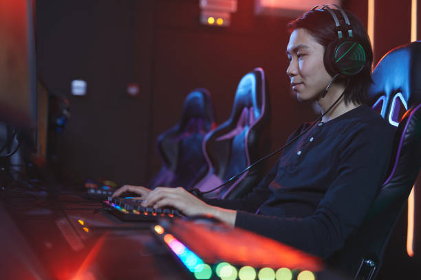 istock Young Asian Man Playing Videogame 1203972745