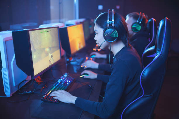 Computer Club High angle view at young Asian man playing video games with pro cyber sport team, copy gaming chair photos stock pictures, royalty-free photos & images