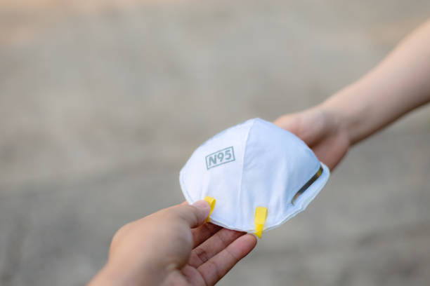 Hand give to / grant / assign / deliver N95 mask or respirator for protect PM 2.5 to other Hand give to / grant / assign / deliver N95 mask or respirator for protect PM 2.5 to other n95 face mask photos stock pictures, royalty-free photos & images