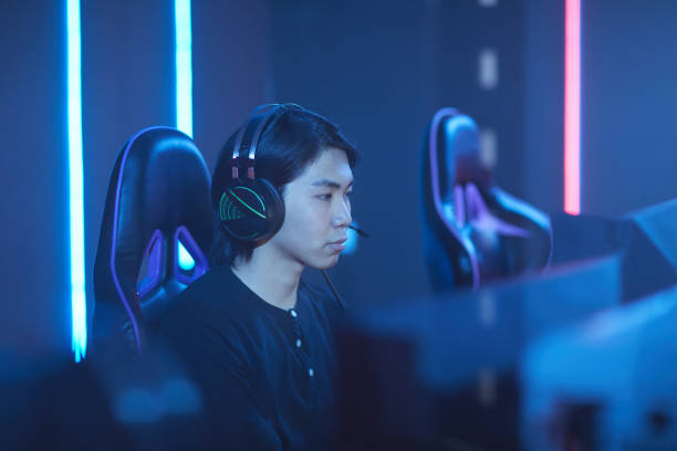 Asian Man Playing Videogames in Dark