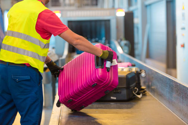 istock Airport service crew unloading luggage 1203973340