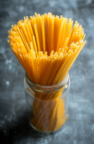 istock Raw dry spaghetti on the rustic wooden background 1203974175