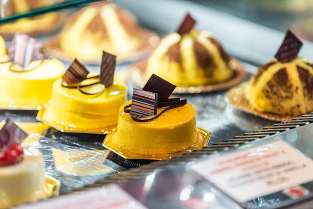 closeup de doces de creme amarelo de sobremesa de chocolate em exposição de bandeja em loja de padaria em florença, itália em famoso mercado - indulgence chocolate cheesecake small - fotografias e filmes do acervo