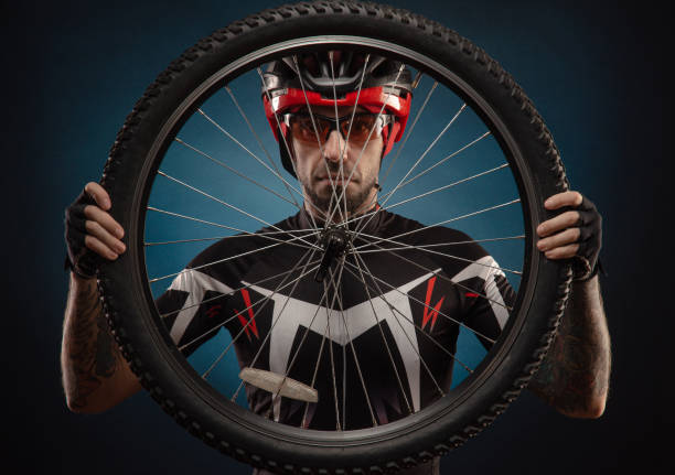 istock guy-cyclist in a Bicycle helmet with a Bicycle wheel 1203975014