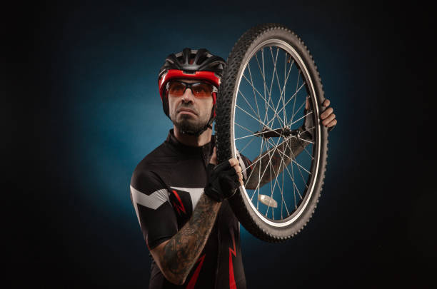 istock guy-cyclist in a Bicycle helmet with a Bicycle wheel 1203975019