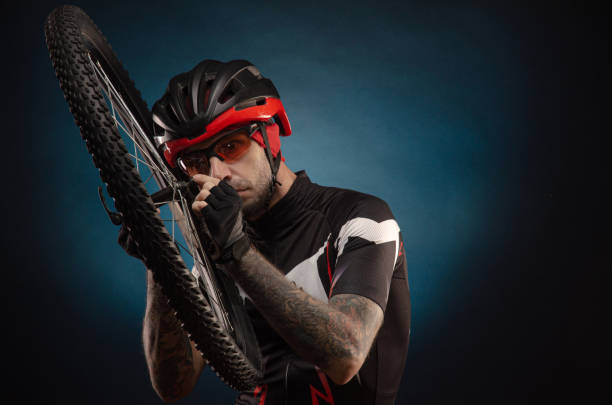 istock guy-cyclist in a Bicycle helmet with a Bicycle wheel 1203975043