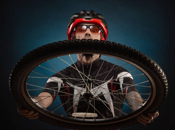 istock guy-cyclist in a Bicycle helmet with a Bicycle wheel 1203975058