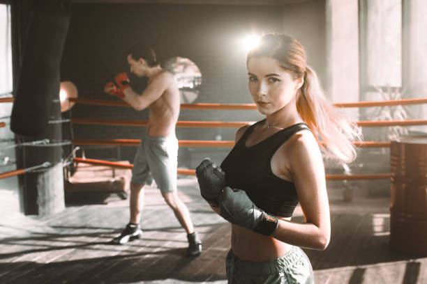 istock Female boxer doing shadow boxing inside a boxing ring. Boxer practicing her moves at a boxing studio. 1203975642