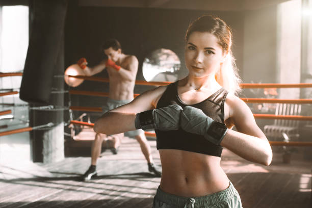 istock Female boxer doing shadow boxing inside a boxing ring. Boxer practicing her moves at a boxing studio. 1203976198