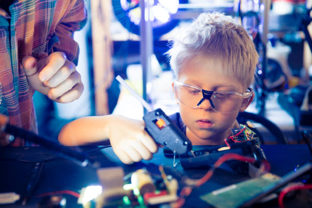 istock Boy and hot glue gun 1203976483