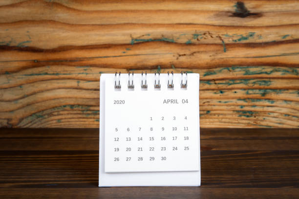 istock 2020 April. White paper calendar on a wooden table. Time planning 1203978794