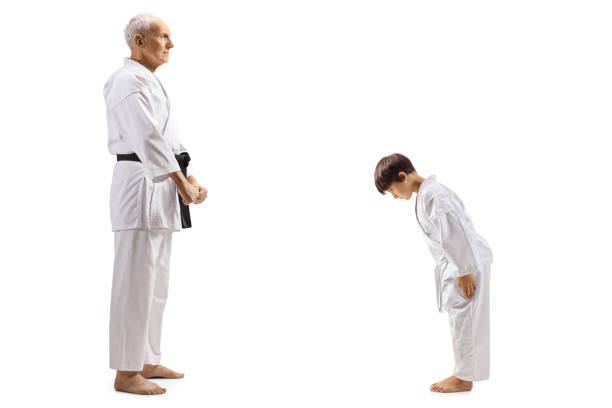 chłopiec w karate kimono kłaniając się przed swoim starszym instruktorem karate - respect karate bowing martial arts zdjęcia i obrazy z banku zdjęć