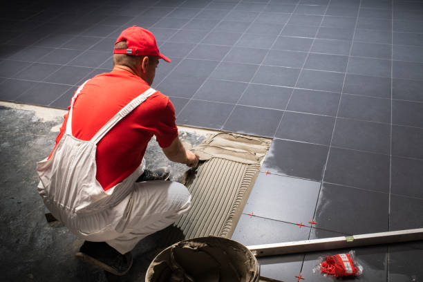 istock A construction worker putting on new floor tiles. 1203980661