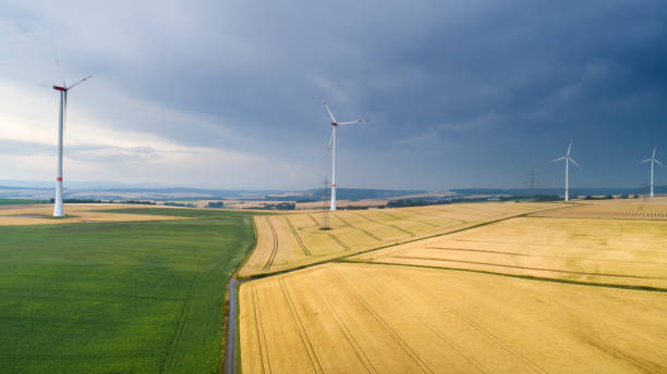 istock Wind turbines and approaching rainstorm - aerial view 1203980841