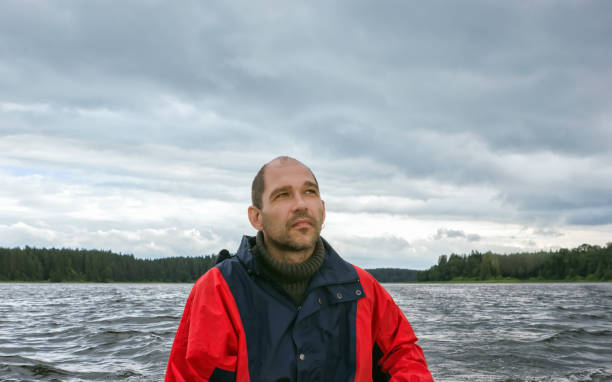 istock Mature Man Against A Overcast Landscape With A Lake 1203982522