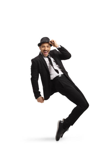 istock Cheerful young man in a black suit dancing 1203982762