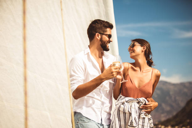 Loving couple spending happy time on a yacht at sea. Loving couple spending happy time on a yacht at sea. Luxury vacation on a seaboat. drinks on the deck stock pictures, royalty-free photos & images