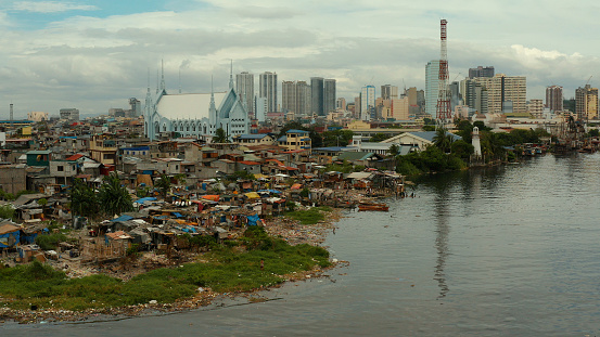 Manila cityscape with slums and dirty river on the background of skyscrapers and business centers view from above.