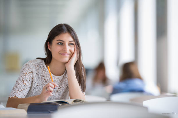 istock Pretty, young college student looking for a book in the library 1203984267