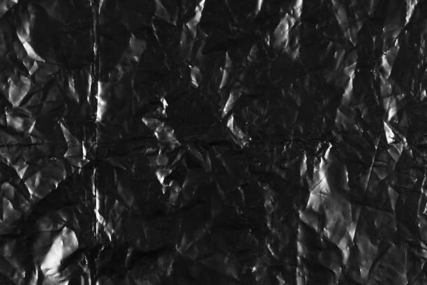 istock Texture of a black crumpled plastic bag. Close up 1203985304