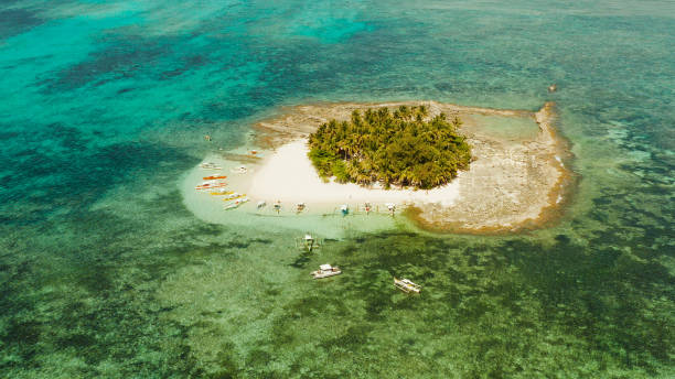 istock Tropical Guyam Island with a sandy beach and tourists 1203985475