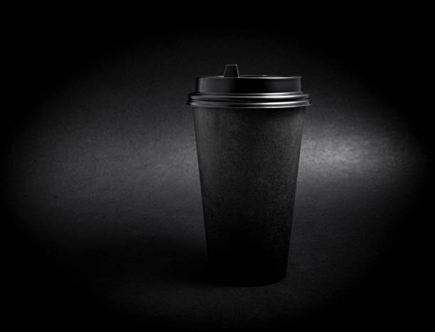 istock Black takeaway paper coffee cup over black background 1203985826